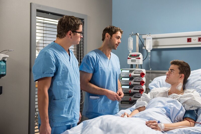 Daniel Ruland (Patrick Moelleken, r.) hat den riskanten Morbus-Crohn-Eingriff gut überstanden. Dr. Ahrend (Roy Peter Link, M.) und Elias Baehr (Stefan Ruppe, l.) klären ihn über die weiteren Schritte auf. – Bild: WDR/​ARD/​Jens-Ulrich Koch