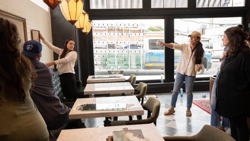 Jo hangs artwork in the seating area of the restaurant as seen on episode 105 of Fixer Upper: Hotel. – Bild: Warner Bros. Discovery, Inc.