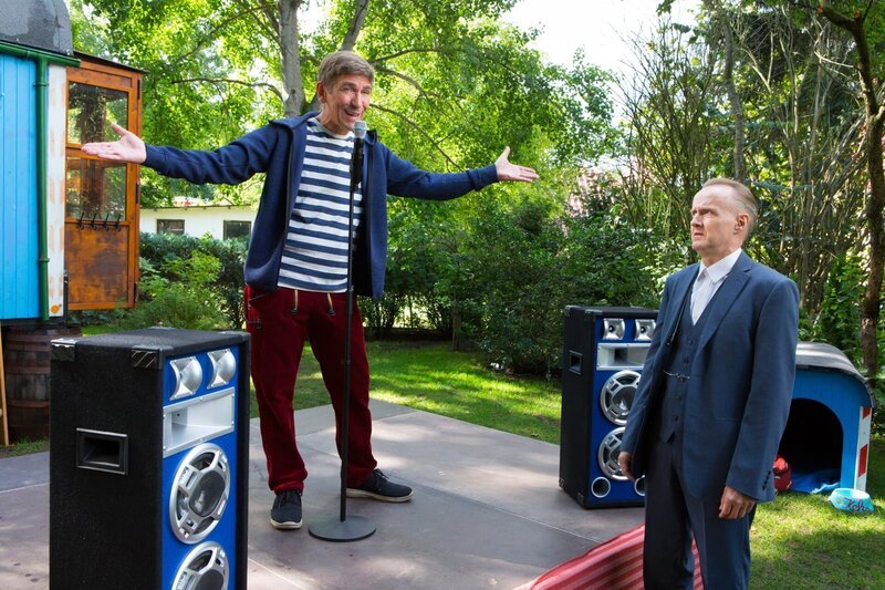Fritz Fuchs (Guido Hammesfahr, l.) gibt alles für seinen Comedy-Auftritt auf der Bühne. Herr Kluthe (Holger Handtke, r.) ist lieber miesepetrig, Albernheiten sind nichts für den Mann vom Ordnungsamt. Bis er plötzlich selbst auf die Bühne muss. – Bild: Zia Ziarno /​ ZDF