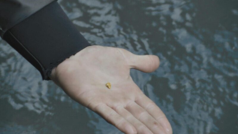 Kleines Goldstück in der Hand. – Bild: Warner Bros. Discovery