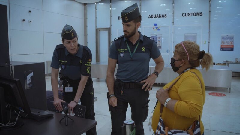 Zollbeamte mit einer Frau. – Bild: Warner Bros. Discovery
