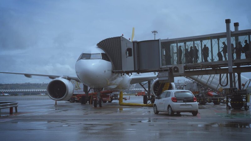 Die Menschen steigen in das Flugzeug ein. – Bild: Warner Bros. Discovery