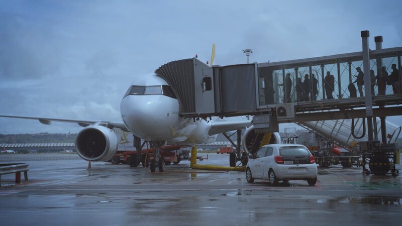 Die Menschen steigen in das Flugzeug ein. – Bild: Warner Bros. Discovery