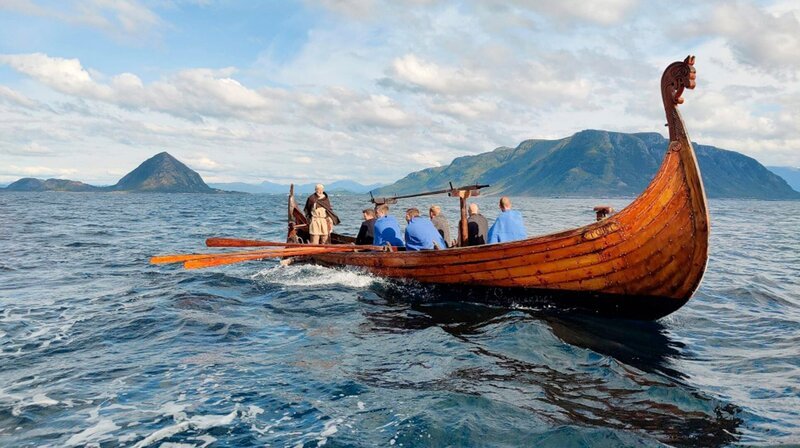 Im kleinen Hafen von Godøya geht Arne Tunheim zu seinem alten Wikingerschiff und rudert mit einigen Männern aufs Meer hinaus. Er kennt die Geschichten von den Wikingern und deren Eroberungsreisen und weiß, wie wichtig diese Tradition für die Inseln ist. – Bild: phoenix/​ZDF/​TAG/​TRAUM Filmproduktion