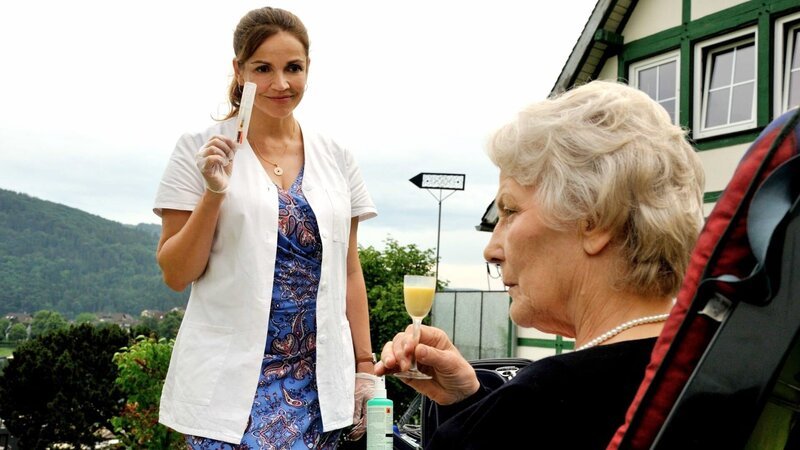 Versorgungsassistentin Vera Mundt (Rebecca Immanuel) lässt sich von den Sticheleien der Patientin Martha Böhl (Marie Anne Fliegel) nicht aus der Reserve locken. – Bild: Romance TV