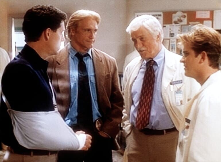 Der Mordverdächtige George (Jeff Allin, l.) wird vom Polizisten Steve (Barry Van Dyke, 2.v.l.), von Dr. Mark Sloan (Dick Van Dyke, M.) und vom Assistenzarzt Dr. Jesse Travis (Charlie Schlatter, r.) befragt. – Bild: CBS Studios Inc.
