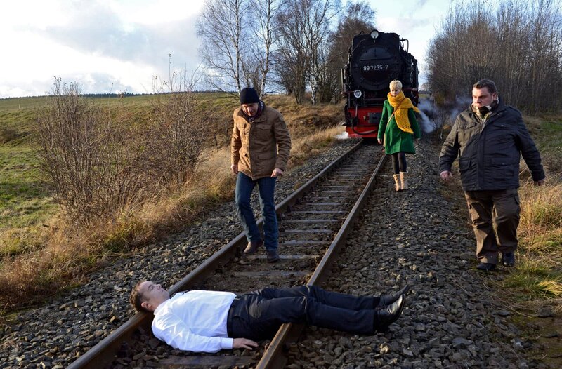 ARD HEITER BIS TÖDLICH – ALLES KLARA II, FOLGE 19 (WH.), „Zur Strecke gebracht“. Ein Mann (Komparse) liegt auf den Gleisen, gerade noch rechtzeitig stoppt die Harzer Schmalspurbahn. Paul Kleinert (Felix Eitner, 2.v.l.), Klara (Wolke Hegenbarth, 2.v.r.) und Ollie (Christoph Hagen Dittmann, r.) eilen herbei. – Bild: ARD/​Marion von der Mehden