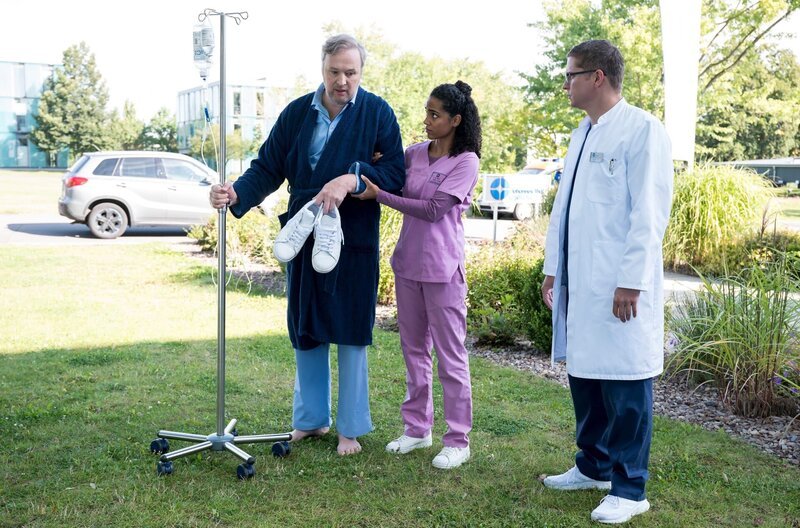 Dr. Emma Jahn (Elisa Agbaglah, M.) findet einen guten persönlichen Zugang zu Elias’ (Stefan Ruppe, r.) Patienten Eddi Tieh (Stephan Grossmann, l.). – Bild: ARD/​Jens-Ulrich Koch