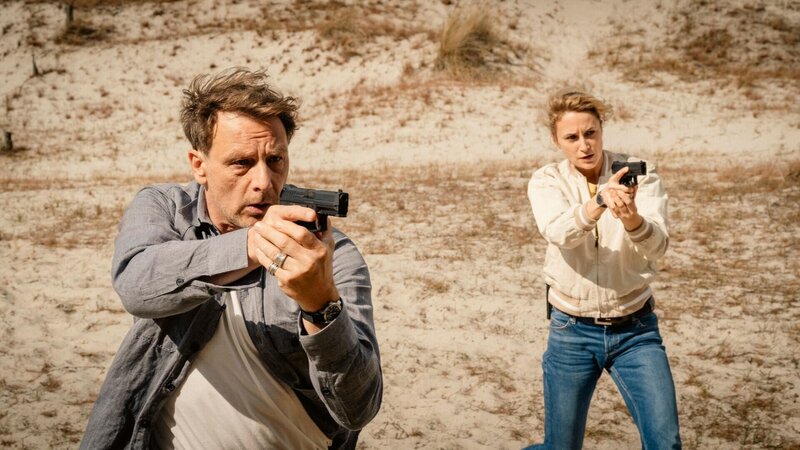 Tjark Wold (Hendrik Duryn) und Femke Folkmer (Pia Barucki) ziehen ihre Waffen. – Bild: RTL /​ Christine Schroeder /​ MadeFor Film GmbH