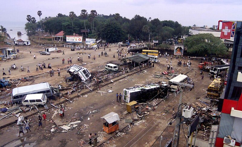 Umgestürzte Busse und Trümmer liegen auf dem Busbahnhof in Galle, Sri Lanka, verstreut. Als ein überfüllter Zug vom Tsunami getroffen wurde, wurde der Zug durch die Wucht des Wassers aus den Schienen geworfen, was zur tödlichsten Zugkatastrophe der Geschichte führte. – Bild: Eranga Jayawardena /​ The Associated Press
