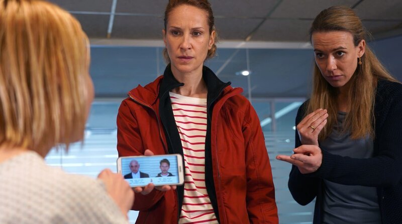 Sonja (Chiara Schoras, Mitte) vernimmt die gehörlose Überlebende Emilia Gruber (Cordula Zielonka). Frau Malik (Kathrin-Marén Enders, r.) unterstützt die Vernehmung in Gebärdensprache. – Bild: ARD Degeto/​Hans-Joachim Pfeiffer