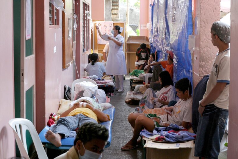 A nurse tends to typhoid fever patients gathered in the hallway of the crowded Jose Rizal hospital in Calamba, Laguna, the Philippines. – Bild: Bloomberg /​ Voltage TV /​ Getty Images South America