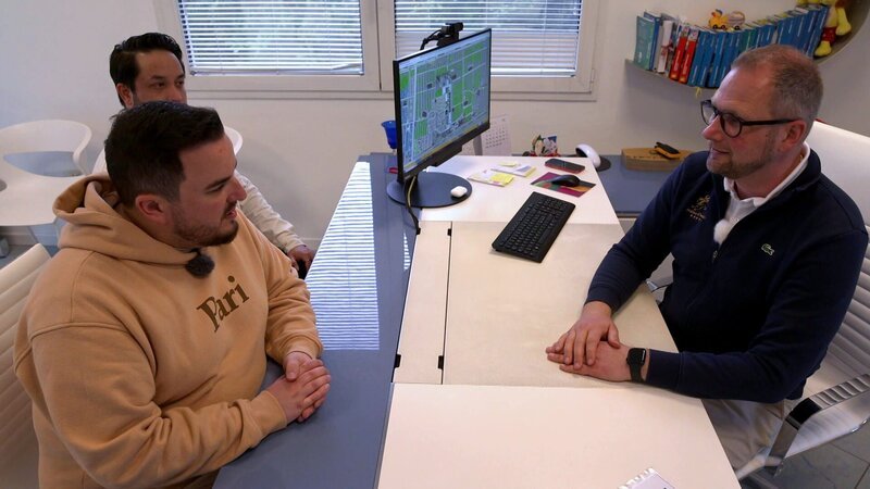 Robin ahnt noch nicht, dass Lex bereits einen Termin für die beiden ausgemacht hat, um die Traumhochzeit zu organisieren. Sie treffen sich mit Campingchef Massimo und einer Weddingplanerin. – Bild: RTLZWEI