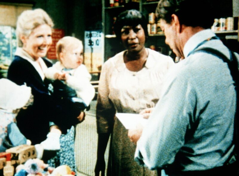 Verdie Foster (Lynn Hamilton, M.) holt Post bei Ike Godsey (Joe Conley, r.) ab. Olivia Walton (Michael Learned, l.) versucht, Verdie aufzuheitern. – Bild: WARNER BROS. INTERNATIONAL TELEVISION