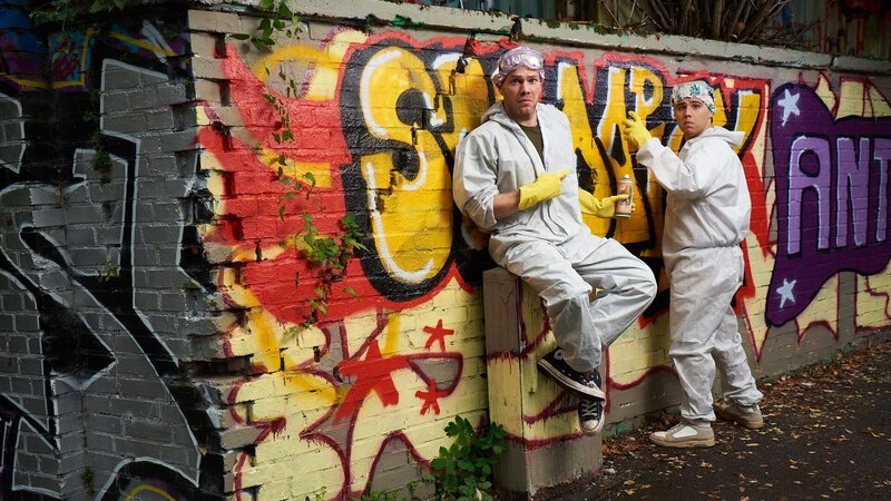 Julian Beil (Ben Münchow, l.) und Ernst Hakke (Diyar Ilhan, r.) in Aktion vor einer bunten Graffiti-Wand – Bild: Heiko Fleischer /​ ZDF