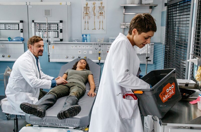 Dr. Marc Lindner (Christian Beermann, l.) versorgt Fine Fischer (Milena Straube, M.), die von einer Giftschlange gebissen wurde.Beim Versuch die Schlage zu identifizieren, wird Theresa (Katharina Nesytowa, r.) ebenfalls gebissen … – Bild: ARD/​Tom Fülle