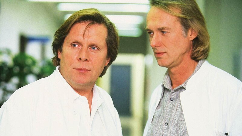 Dr. Christian Roehrs (Simien Rühaak, r.) will bei Alex eine Geschlechtsumwandlung durchführen. Dr. Stefan Frank (Sigmar Solbach) ist dagegen. – Bild: Mediengruppe RTL
