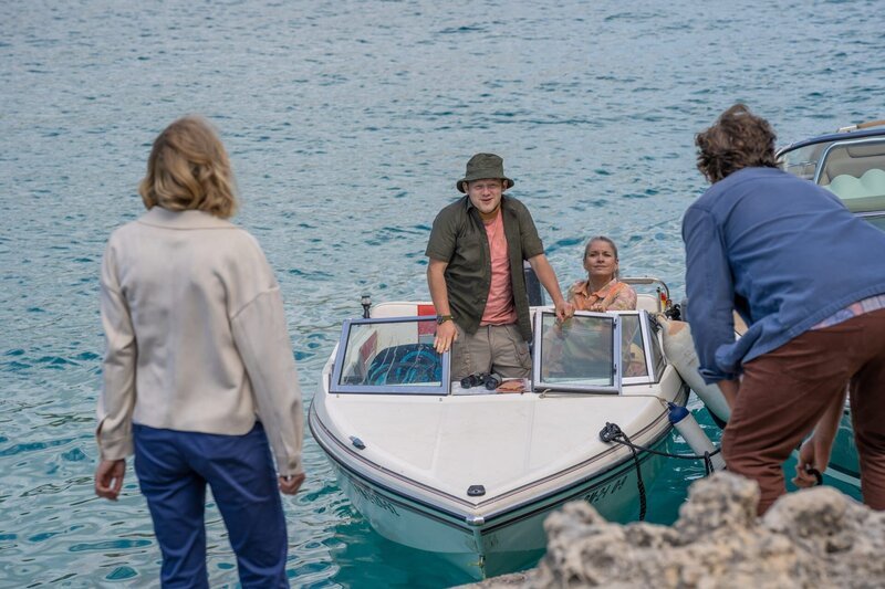 Miranda (Elen Rhys, l.) und Max (Julian Looman, r.) sitzen auf der Insel fest. Doch plötzlich taucht ein anderes Boot auf – zwei Unbekannte (Michael Jibson, 2.v.l. und Caroline Sheen, 2.v.r.) steuern direkt auf sie zu. – Bild: ZDF und Mark Bourdillon