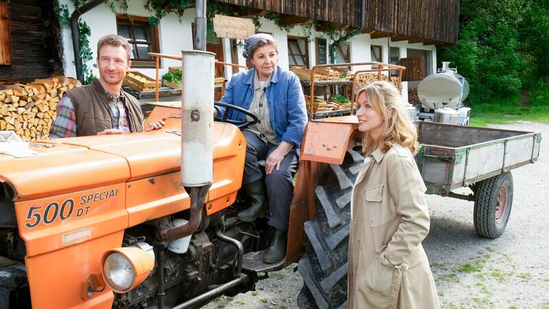 Der Bergdoktor Staffel 16 Getrennte Welten – Teil 1 Ein Mann und zwei Frauen, die eine sitzt auf dem Traktor: Heiko Ruprecht als Hans Gruber, Monika Baumgartner als Lisbeth Gruber, Nathalie Schott als Julia Andermatt – Bild: SRF/​ZDF/​Erika Hauri