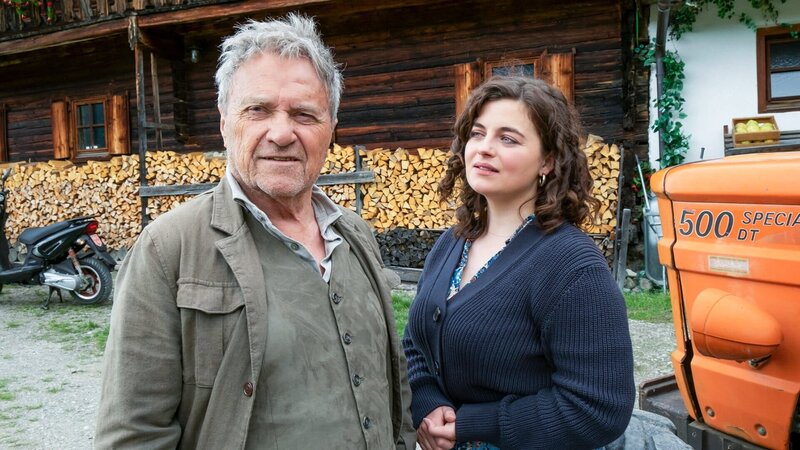 Der Bergdoktor Staffel 16 Getrennte Welten – Teil 2 Ein Mann und zwei Frauen, die eine sitzt auf dem Traktor: Heiko Ruprecht als Hans Gruber, Monika Baumgartner als Lisbeth Gruber, Nathalie Schott als Julia Andermatt – Bild: SRF/​ZDF/​Erika Hauri