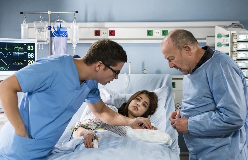 Coras (Lisa-Marie Koroll, M.) Hand ist nicht richtig durchblutet. Elias (Stefan Ruppe, l.) reagiert sofort. Coras Opa Wilhelm Gottschalk (Hans Klima, r.) macht sich große Vorwürfe, dass seine Enkelin sich in seiner Werkstatt so schwer verletzt hat. – Bild: ARD /​ Jens-Ulrich Koch