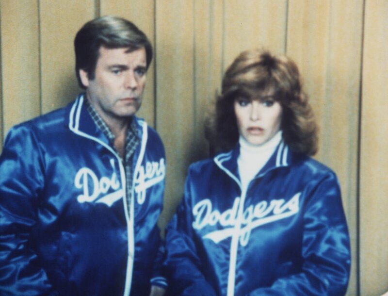 Auf der Baseballkartenmesse suchen Jonathan (Robert Wagner, l.) und Jennifer Hart (Stefanie Powers, r.) nach der gestohlenen wertvollen Kartensammlung. Werden die beiden fündig? – Bild: Columbia Pictures