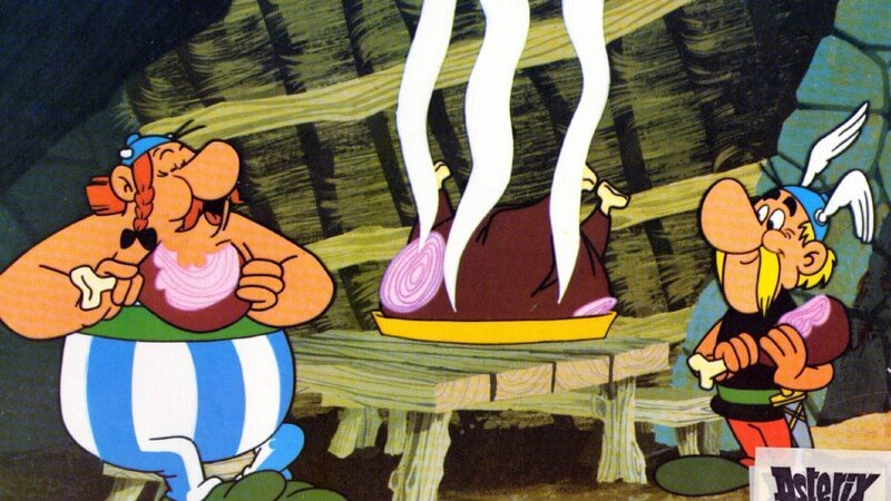 Aster (re.) und Oberlix (li.) lassen es sich schmecken. Noch wissen sie nicht, dass die Römer ihnen auflauern. – Bild: SUPER RTL Aster (re.) und Oberlix (li.) lassen es sich schmecken. Noch wissen sie nicht, dass die Römer ihnen auflauern. – Bild: SUPER RTL