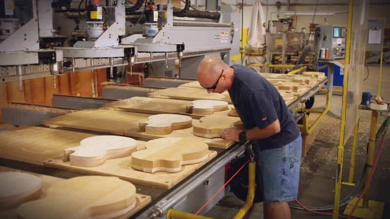 Gibson worker cutting guitar shape from wood. – Bild: The National Geographic Channel Gibson worker cutting guitar shape from wood. – Bild: The National Geographic Channel