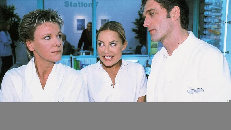 Nikola (Mariele Millowitsch, l.) traut ihren Ohren nicht, als Dr. Schmidt (Walter Sittler) in aller Öffentlichkeit Mariannes (Xenia Seeberg) große Fähigkeiten lobt. – Bild: RTL /​ Guido Engels