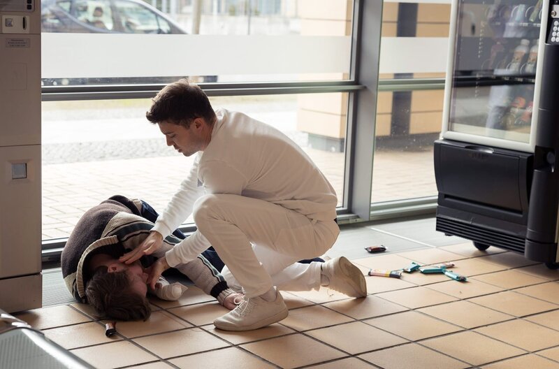 Kris Haas (Jascha Rust, re.) wundert sich, dass der für gesundes Essen berühmte Starkoch Tom Müller (Benjamin Kramme, li.) den Süßigkeiten-Automaten plündert. Im nächsten Moment bricht Tom Müller auch schon zusammen. – Bild: MDR/​Saxonia Media/​Rudolf Wernicke