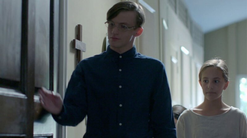 Wallace (Michael Buoni) leads a young girl to a private space. – Bild: Discovery Communications