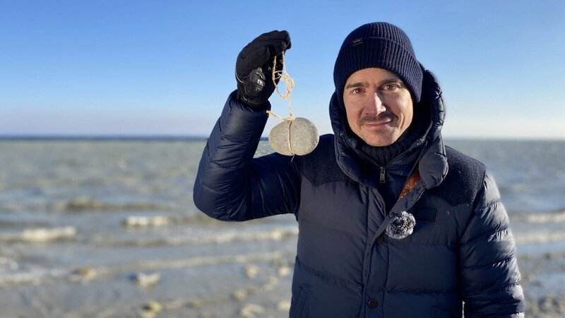 Einstein Mysterium vom Bodensee: Was verraten uns die 170 Steinhügel? Moderator Tobias Müller hält einen jungsteinzeitlichen Fund in der Hand. – Bild: SRF