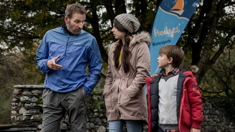 Robert (Christopher Eccleston, l.) instruiert Louisa (Harriet Cains, M.) und Joe (Max True, r.) wie sie sich verhalten sollen, um ihre Identität geheim zu halten. – Bild: ZDFneo