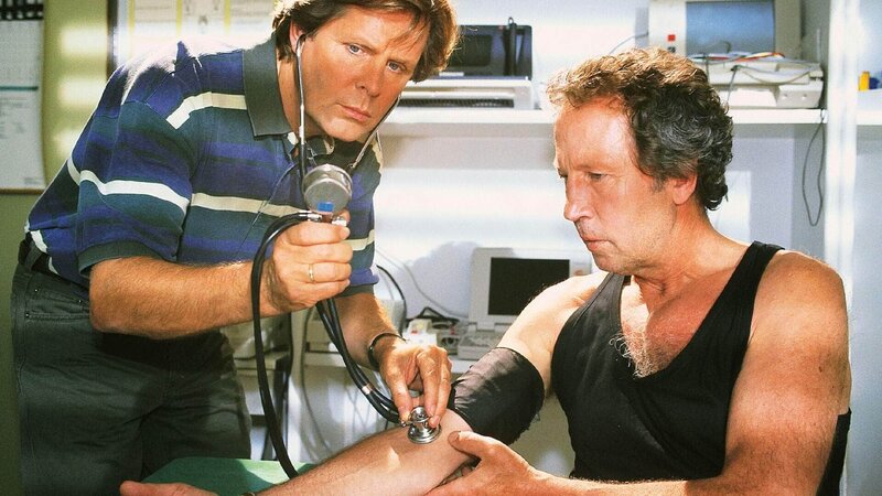 Dr. Stefan Frank (Sigmar Solbach, l.) hat seine Hochzeitsreise unterbrochen, um seinen Freund Dr. Ulrich Waldner (Hartmut Becker) zu untersuchen. Er stellt etwas Schreckliches fest … – Bild: MG RTL D /​ Elke Werner