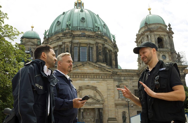 Vor dem Berliner Dom versucht Security-Mann Arne Litkowski (Martin Baden, r.) alles von sich zu weisen, womit ihn Fahri Celik (Hassan Akkouch, l.) und Axel Sommer (Oliver Breite. 2.v.l.) konfrontieren. – Bild: ARD/​Daniela Incoronato