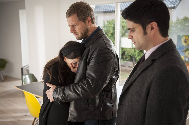 Können die hochschwangere Frau des Mordopfers (Stephanie Kämmer) nur schwer trösten: Mick (Henning Baum) und Andreas (Maximilian Grill). – Bild: SAT.1 /​ Martin Rottenkolber