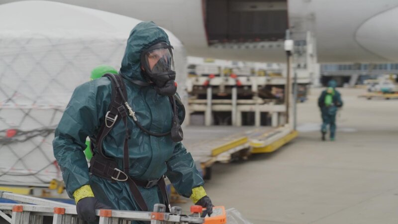 Das HazMat-Team wird gerufen, um eine unbekannte Flüssigkeit zu testen, die aus einem Frachtflugzeug ausgetreten ist. Der Einsatz wird mit äußerster Vorsicht durchgeführt, da die Flüssigkeit giftig sein könnte. Drei Mitglieder des Bodenpersonals sind bereits gefährdet. – Bild: ITV Studios Australia /​ ITV Studios Australia
