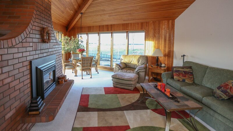 The living room in the Island View House features a large and unique brick fireplace, as seen on HGTV’s Beach Hunters. – Bild: WSP 6D DS1 /​ ©2017,HGTV/​Scripps Networks, LLC. All Rights Reserved