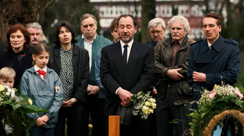 Hajo Gärster (Thorsten Merten, M. mit Komparsen) auf der Beerdigung seines Neffen Reiko Böttcher. Anwalt Dr. Würz (Steffen C. Jürgens, r.) – Bild: ARD/​Merav Maroody