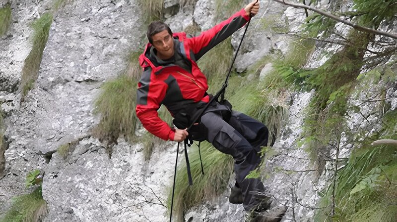 Bear Grylls abseiling down rock face. – Bild: Chloe Pearne
