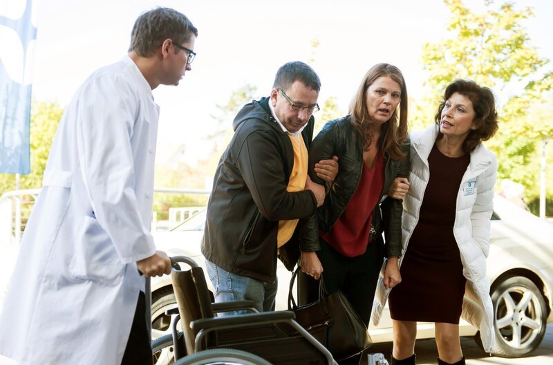 Dr. Elias Bähr (Stefan Ruppe, l.) und Prof. Karin Patzelt (Marijam Agischewa, r.) nehmen Sandra Prader (Hanne Wolharn, 2.v.r. mit Komparse) in Empfang. Die Geschäftsfrau ist bereits seit Jahren am Johannes-Thal-Klinikum in Behandlung. – Bild: ARD/​Jens Ulrich Koch