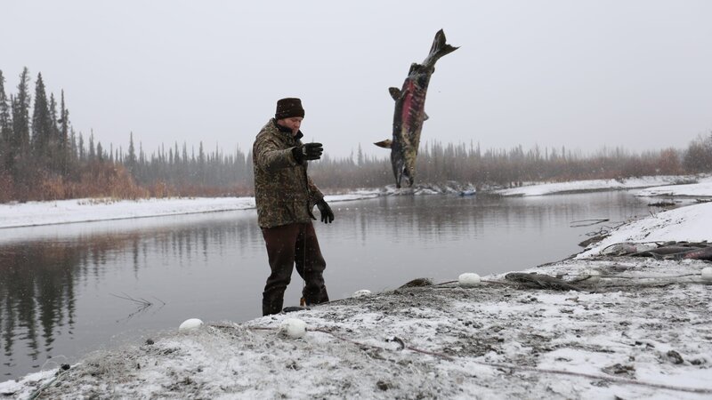 Tyler throwing fish in the air in the frozen tundra near a pond. – Bild: Discovery Communications