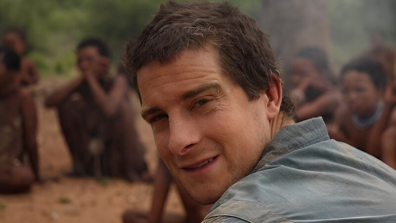 Portrait of Bear Grylls in front of San Bushmen in Namibia. – Bild: Warner Bros. Discovery