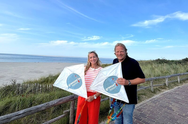 Mit den „Grenzenlos köstlich“-Drachen: Tamina Kallert (l) und Björn Freitag fragen sich, ob der Wind stark genug ist, um sie steigen zu lassen. – Bild: WDR/​2bild GmbH/​Anja Tanas