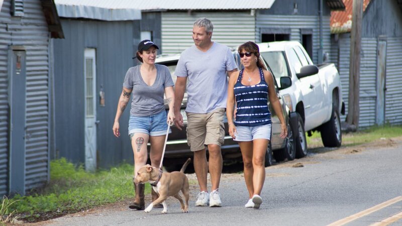 BOAT TRAINING:  Lizzy walking with the adopters and Minipants on a leash. – Bild: Animal Planet /​Discovery Communications, LLC