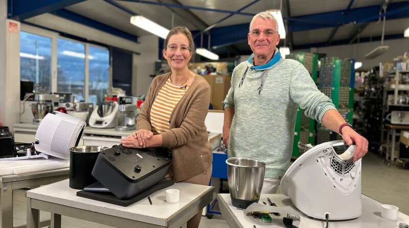Kochende Küchenmaschinen erfreuen sich großer Beliebtheit. Aber gerade für das Kultgerät aus Wuppertal, den Thermomix, muss man tief in den Geldbeutel greifen. Deutlich günstigere Alternativen werben größtenteils mit den gleichen Funktionen. Gemeinsam mit Reparatur-Experte Armin Lüth (r.) schraubt Yvonne Willicks (l.) drei der Trendgeräte auf. Rechtfertigt ein Blick ins Innenleben die großen Preisunterschiede? Die spannenden Ergebnisse gibt es im neuen Haushalts-Check mit Yvonne Willicks. – Bild: WDR/​Solis TV/​Melanie Grande