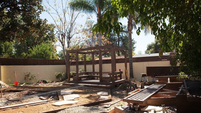 Das Zuhause von Chris und Kimberly hat spanischen Flair, ihrem Garten muss Landschaftsdesignerin Sara noch etwas Flair einhauchen. Sie stellt eine Lounge-Area auf, in deren Mitte man ein knisterndes Lagerfeuer veranstalten kann und sorgt dafür, dass sich der kleine Sohn der beiden in seine Spielecke im Grünen zurückziehen kann. – Bild: HGTV