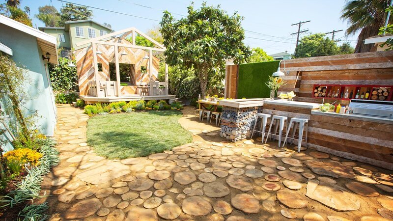 Die Musiker Kevin und Sara unterhalten ihre Gäste gerne in ihrem eigenen Garten. Landschaftsdesignerin Sara sorgt dafür, dass nicht nur die Musik bezaubernd ist, sondern auch das Ambiente. Sie stellt eine Bar auf, gestaltet einen Essbereich sowie eine kleine Bühne mit dazugehöriger Lounge-Area. – Bild: HGTV