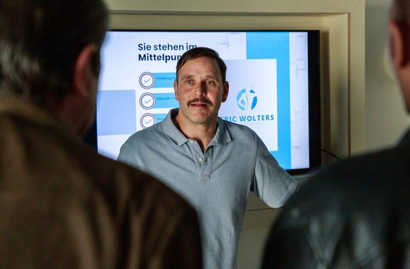 Der ehemalige Geschäftspartner der eingefrorenen Toten, Eric Wolters (Patrick Nellessen, M.), ist gestresst, dass die Ermittlungen 10 Jahre nach ihrem Tod wieder laufen, da er erneut von den Kommissaren Jerry Paulsen (Peter Marton, r.) und Benedikt Beissl (Andreas Giebel, l.) verhört wird. – Bild: ARD/​Benjamin Strobel