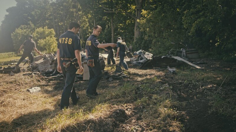 Nachdem die Absturzstelle von Air Midwest Flight 105 gesichert wurde, treffen die Ermittler des NTSB (gespielt von Peter Deiwick und Connor Thompson) am Unfallort ein, um das Wrack zu untersuchen und nach Antworten auf die Frage zu suchen, warum die DC-9 nur wenige Augenblicke nach dem Start vom Himmel fiel. – Bild: Cineflix 2024
